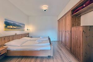 Schlafzimmer mit gemütlichem Doppelbett und Kleiderschrank