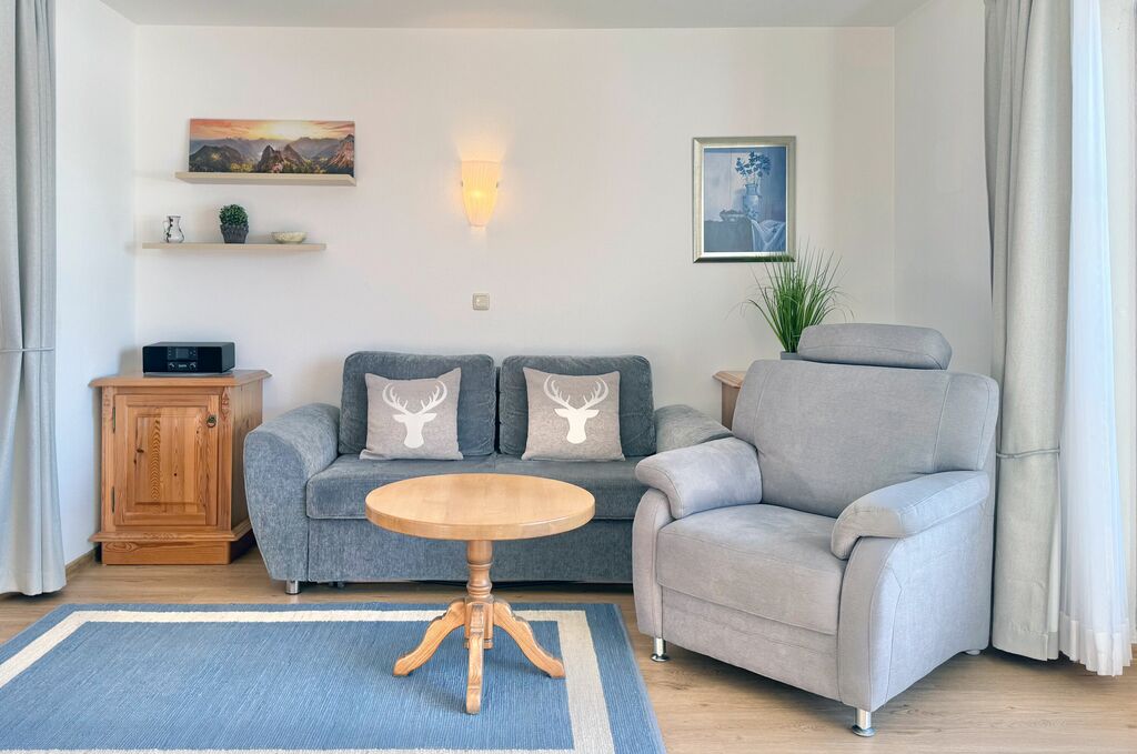 Wohnzimmer mit gemütlicher Couch, Sessel und Couchtisch