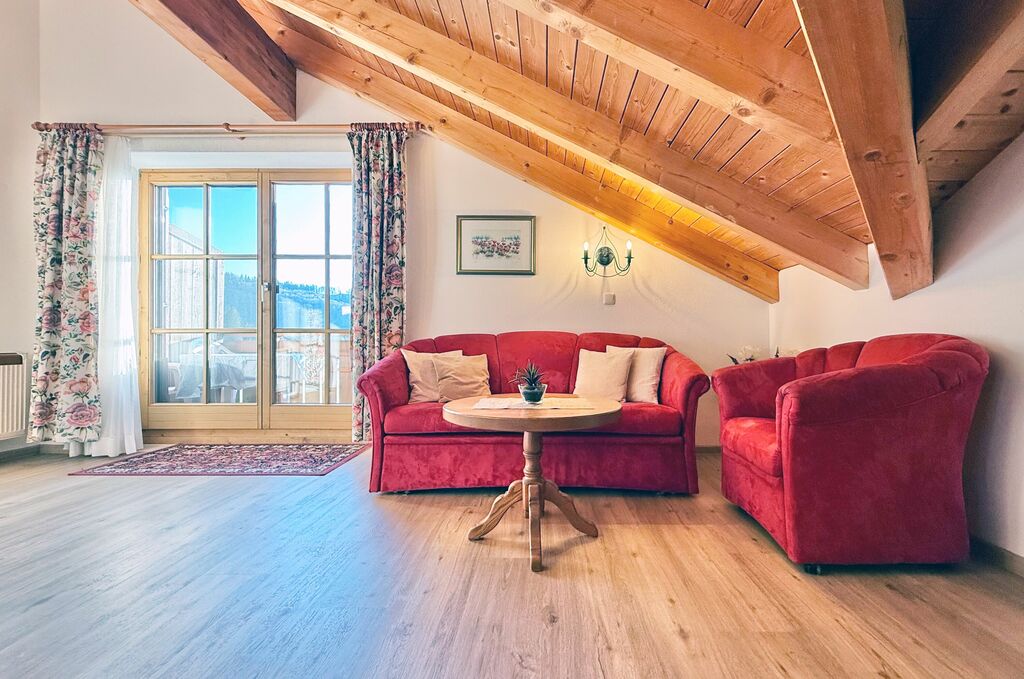 Wohnbereich mit Couch, Sessel, Couchtisch und Balkon