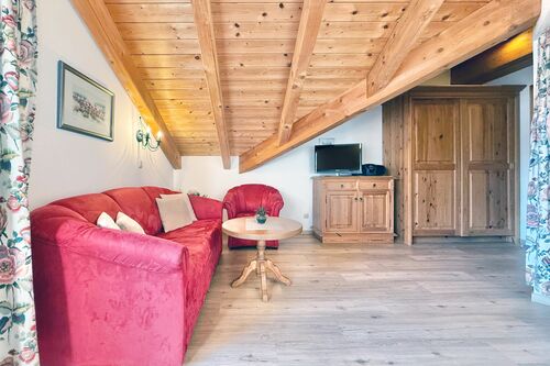 Wohnzimmer mit Couch, Sessel, Couchtisch und TV-Sideboard