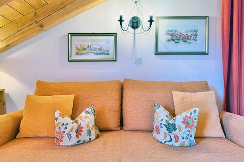 Wohnbereich mit gemütlicher Couch und Wandbildern