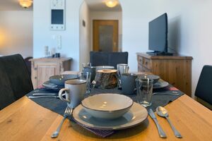 Gedeckter Esstisch mit Blick in die offene Küche Detail