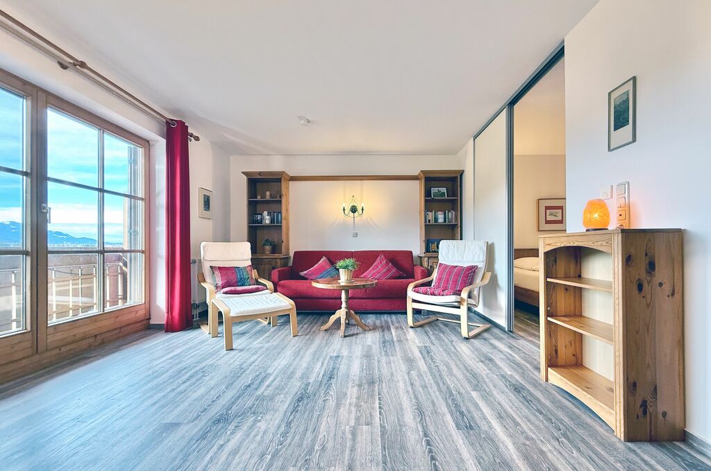 Wohnbereich mit Balkon uns Ausblick auf die Alpen