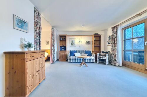 Wohnbereich mit Couch, Sessel, Couchtisch und Sideboard