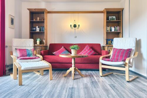 Wohnzimmer mit gemütlicher Couch, Relax-Sessel und Couchtisch