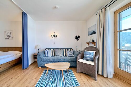 Wohnzimmer mit Couch, Sessel, Couchtisch und Wanddekoration