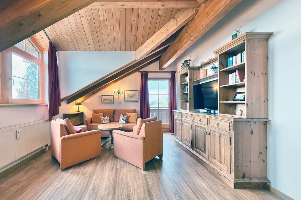 Wohnzimmer mit Couch, zwei Sesseln, Couchtisch und TV-Sideboard