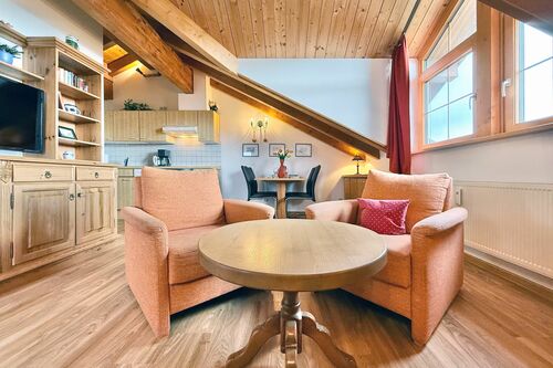 Wohnbereich mit großem Fenster, zwei Sesseln und Couchtisch