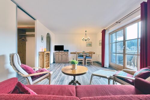 Wohn- und Essbereich mit Couch, Esstisch und TV-Sideboard