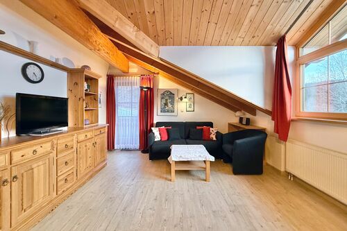 Wohnzimmer mit Couch, Sessel, Couchtisch und TV-Sideboard