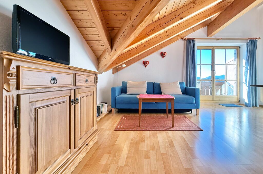 Wohnbereich mit Couch, Couchtisch, TV-Sideboard und Balkon