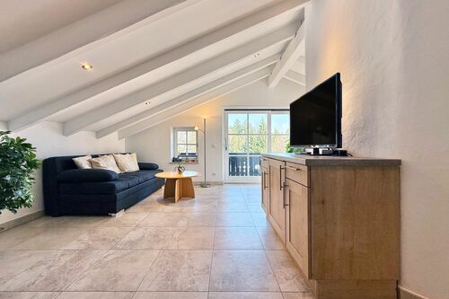 Wohnzimmer mit gemütlicher Couch und TV-Sideboard