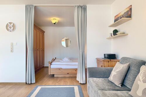 Wohnzimmer mit Couch und kleinem Sideboard-Schrank